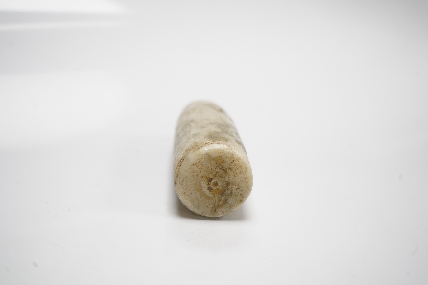 An Egyptian incised alabaster cosmetics bottle (bullet shaped), 7.5cm. Condition - restored